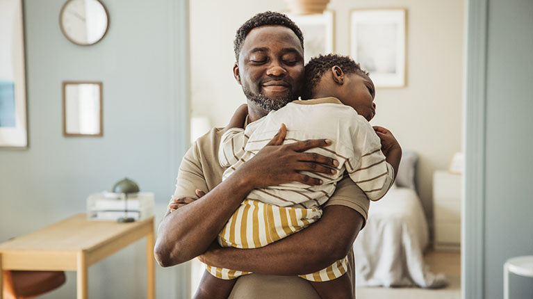 Dad holding sleeping son