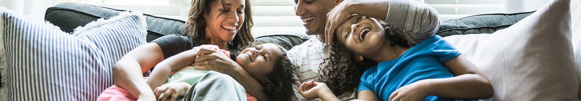 Parents sitting on a couch hugging children