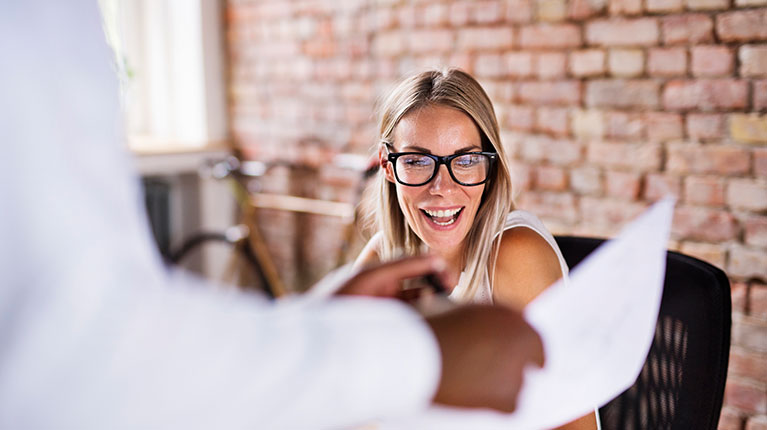 Employee giving another employee paperwork.
