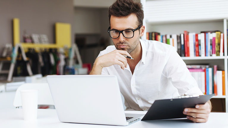Man with glasses on his computer.