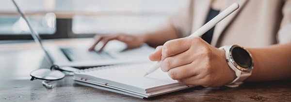 person writing at a desk