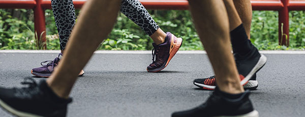 Person walking in tennis shoes with peers 