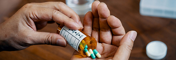 person pouring pills into their hand