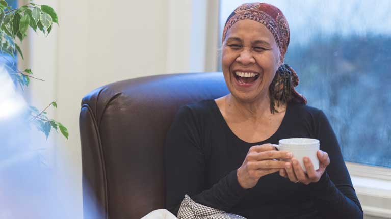 Nurse showing patient in a hospital bed a digital tablet.