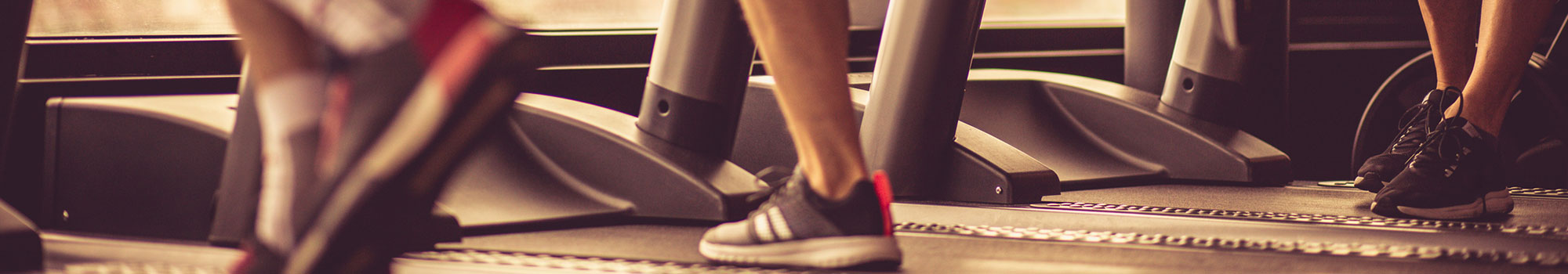 People running on treadmills at the gym.