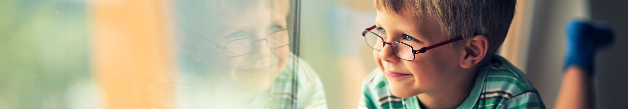 Little boy drawing by the window