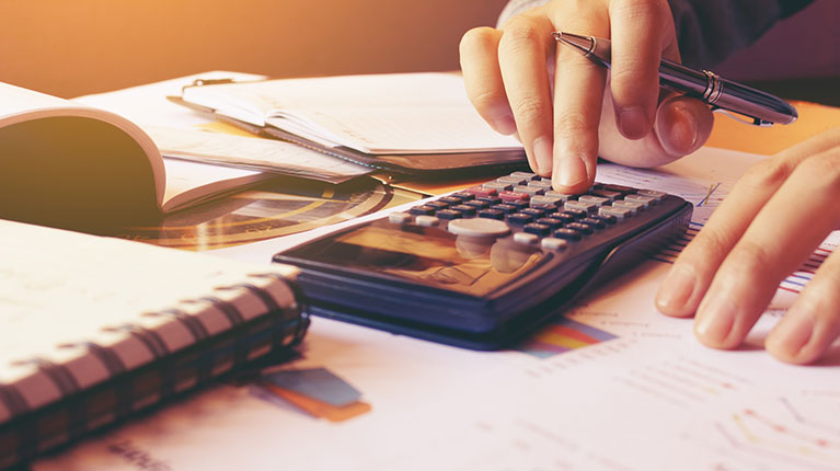 Person clicking a calculator to calculate costs.