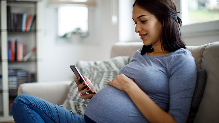 Pregnant woman looking at her phone
