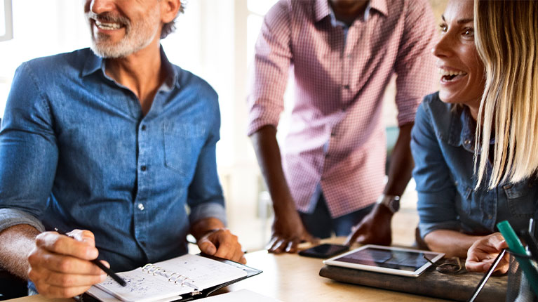 Three employees brainstorming in a meeting.