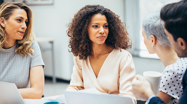 Four employees brainstorming in a meeting.