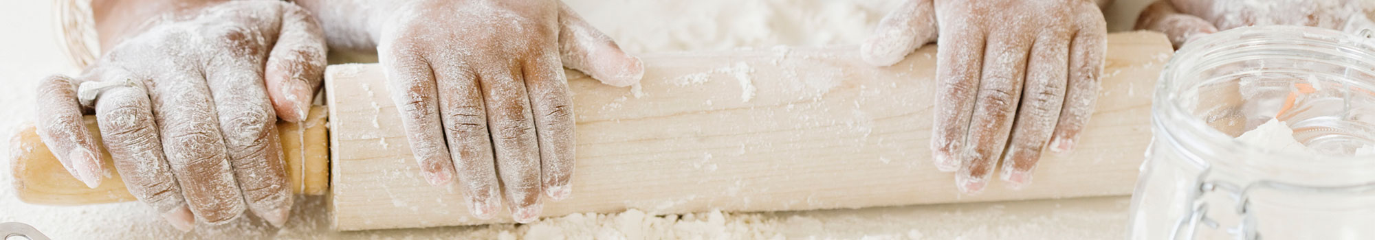 Mom and daughter rolling out dough