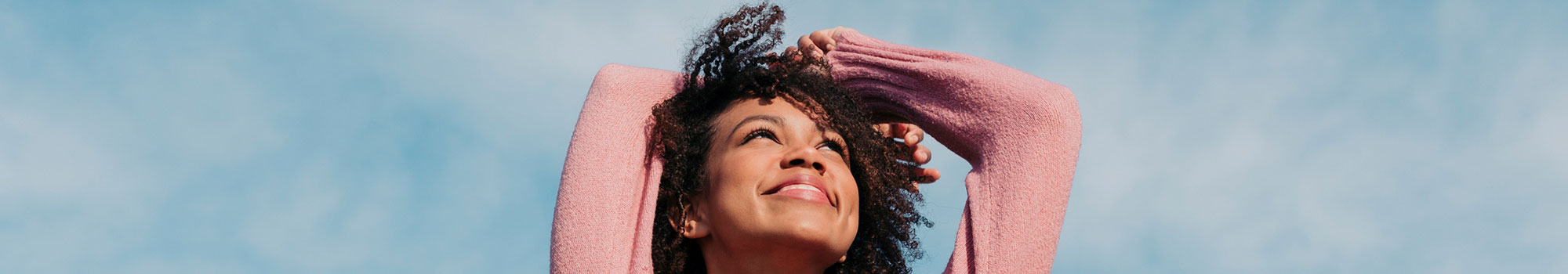 Happy woman looking up at sky.
