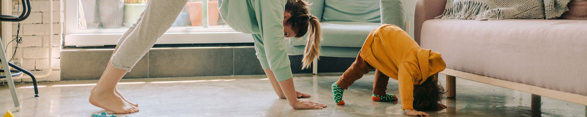 Mom and toddler doing yoga in their living room.